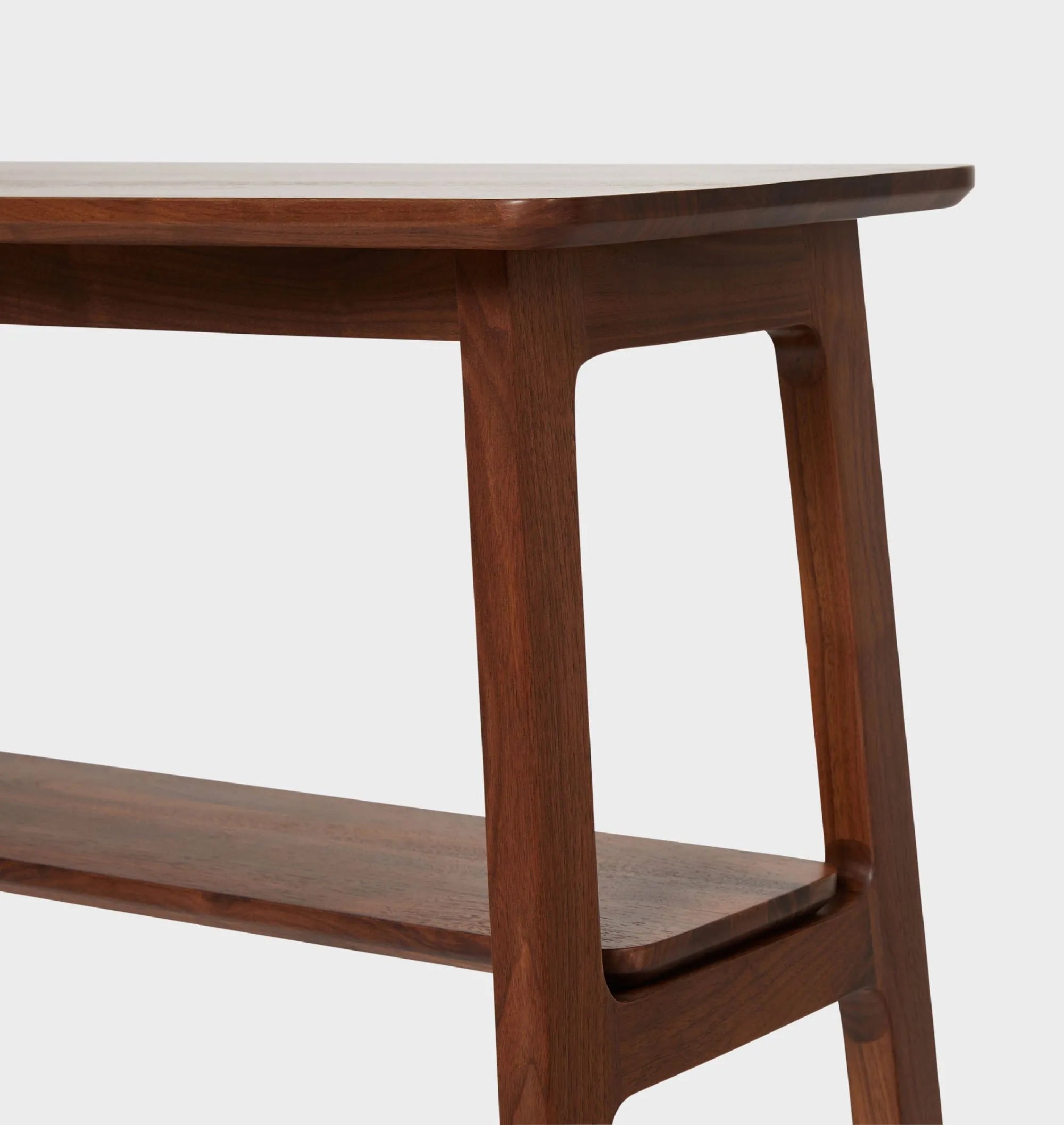 Mid century console table featuring open design, tapered legs, and dual shelves for storage.