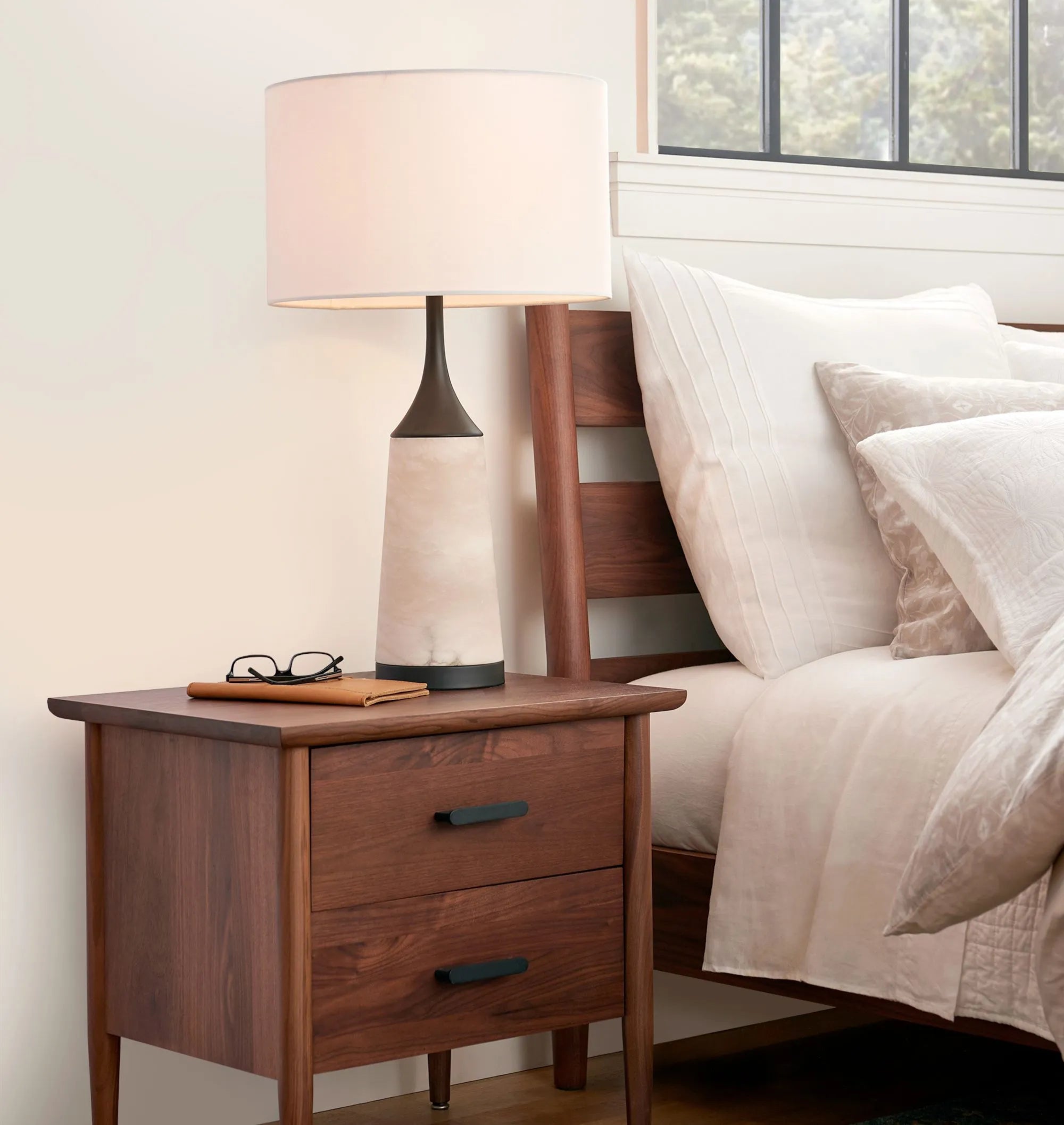Mid century nightstand with double drawers, tapered legs, and black metal handles.
