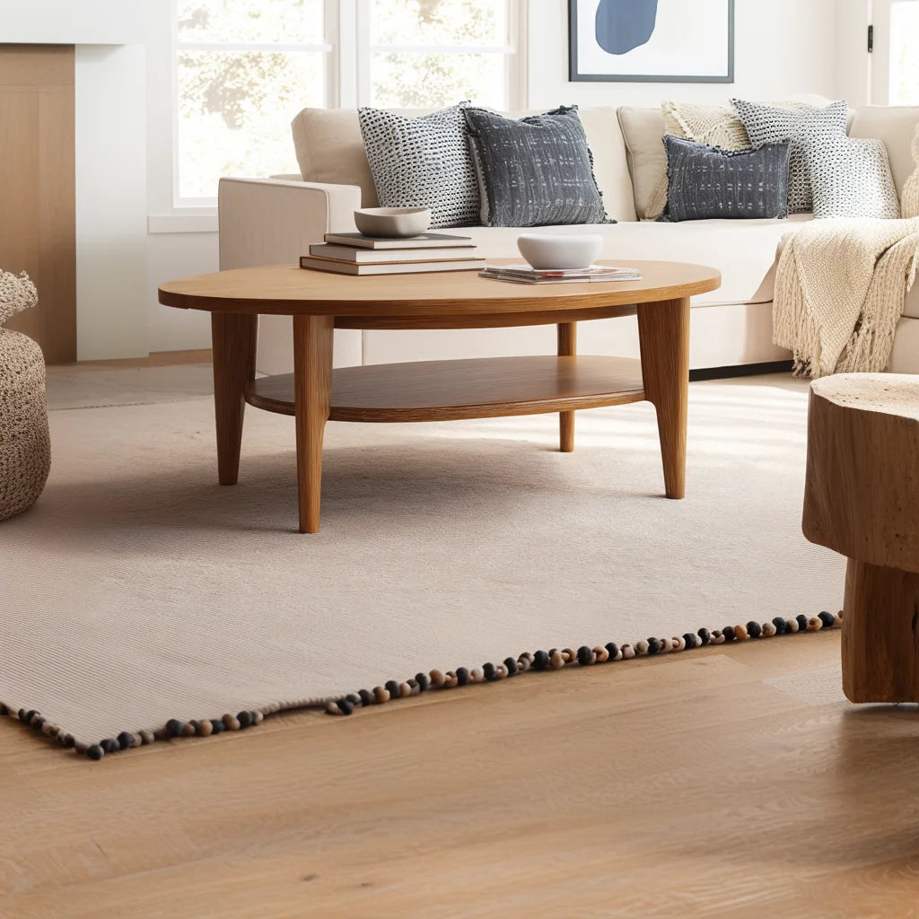 Oval coffee table with shelf styled in a bright neutral-toned living room