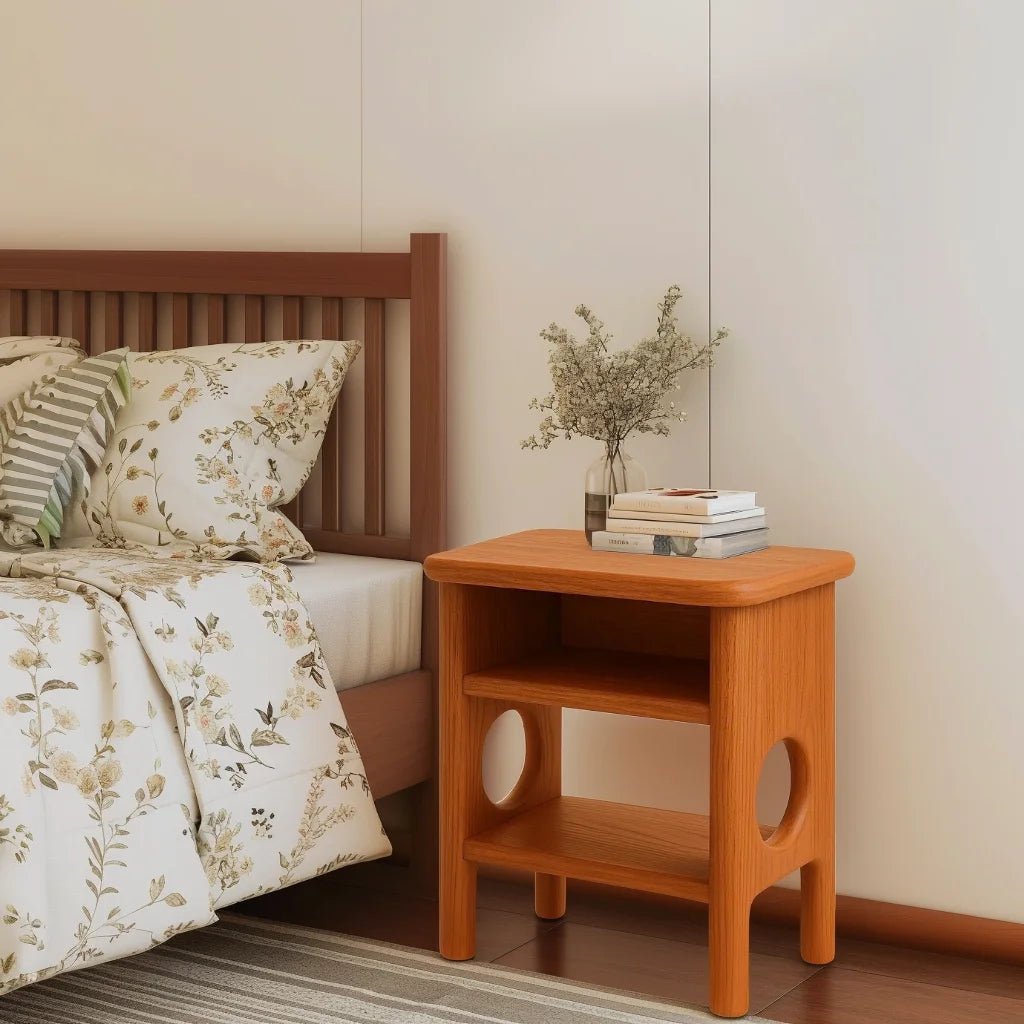 Rounded nightstand with open shelving and sculptural cutout legs in a cozy bedroom corner