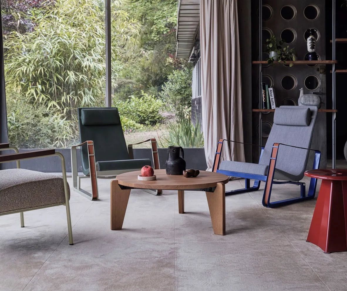 Stylish round coffee table with books and decorative flowers in a modern living room