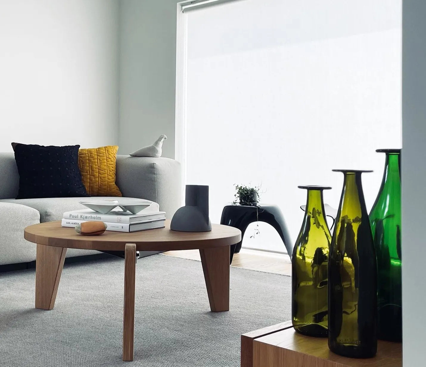 Stylish round coffee table with books and decorative flowers in a modern living room