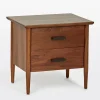 Mid century nightstand with double drawers, tapered legs, and black metal handles.