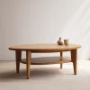 Oval coffee table with shelf styled in a bright neutral-toned living room