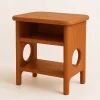 Rounded nightstand with open shelving and sculptural cutout legs in a cozy bedroom corner