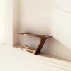 Sculptural console table with asymmetrical leg and open base in modern hallway